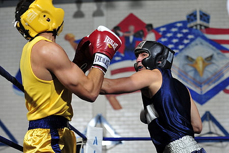 two men boxing on blue roped ring