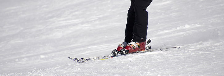 person riding pair of red-and-gray ice skates