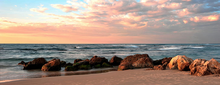 brown stones on seashore during sunrise