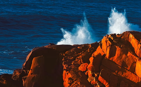 water splashing through brown cliff