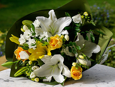 close up photo of yellow roses and white lilies bouquet