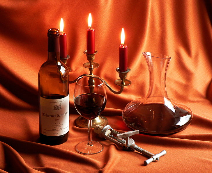 photo of wine bottle, wine glass, and candelabra