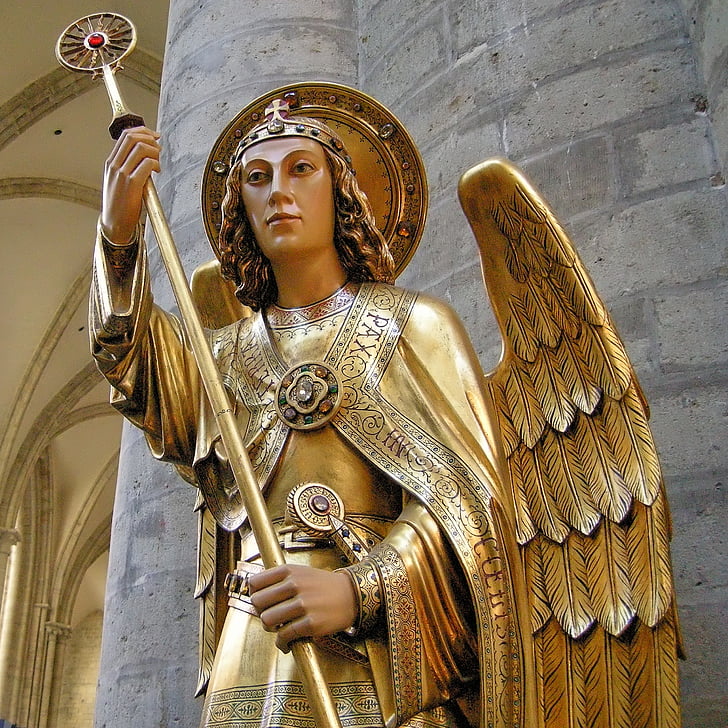 low angle of oangel wearing gold suit holding staff statue