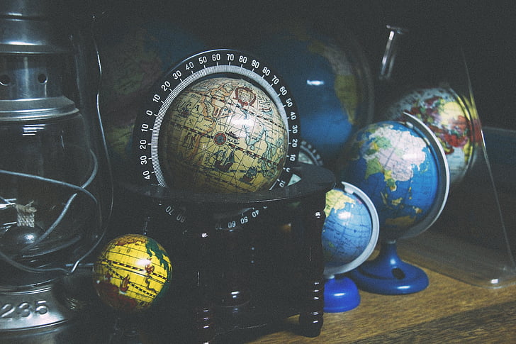 black terrestrial globe and three desk globes