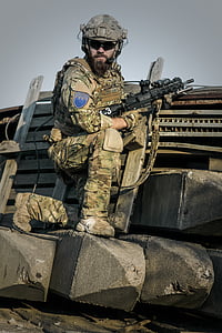 soldier kneeling while holding black rifle