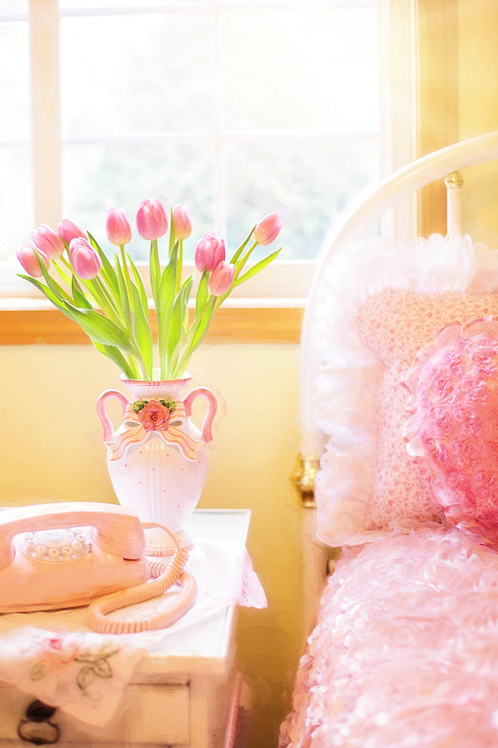 pink tulips in vase on side table
