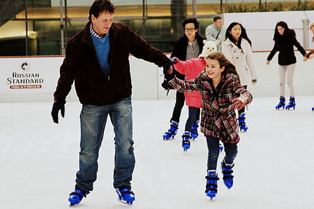 man holding girl white wearing inline skates