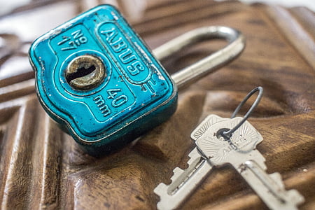 two gray keys beside teal padlock