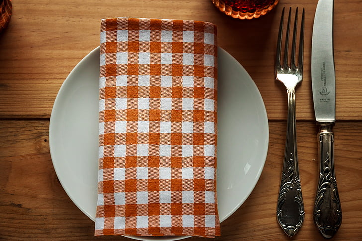 white ceramic plate beside fork and knife