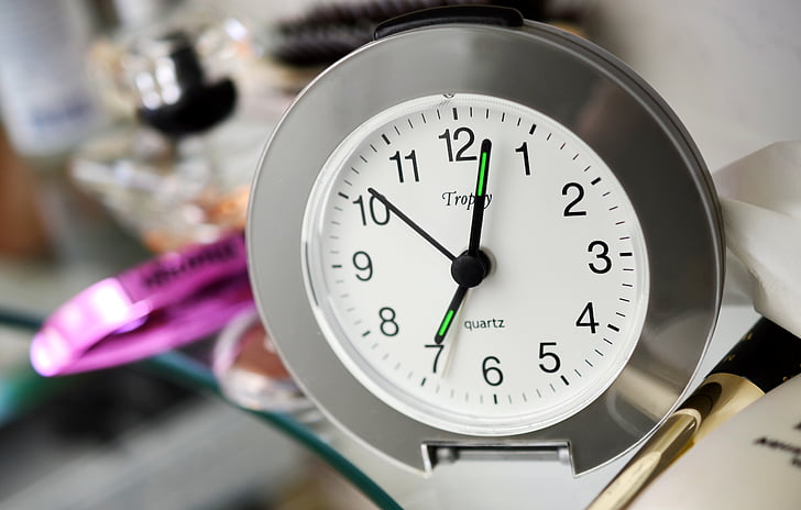 round silver analog clock reading at 7:03