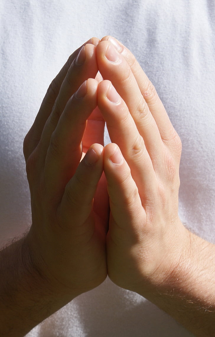 person wearing white top praying