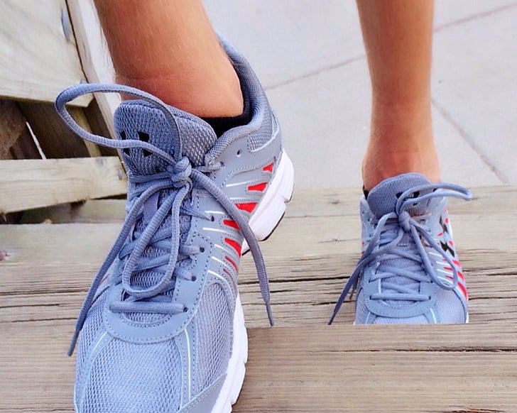 person wearing gray-and-red running shoes stepping on stairway