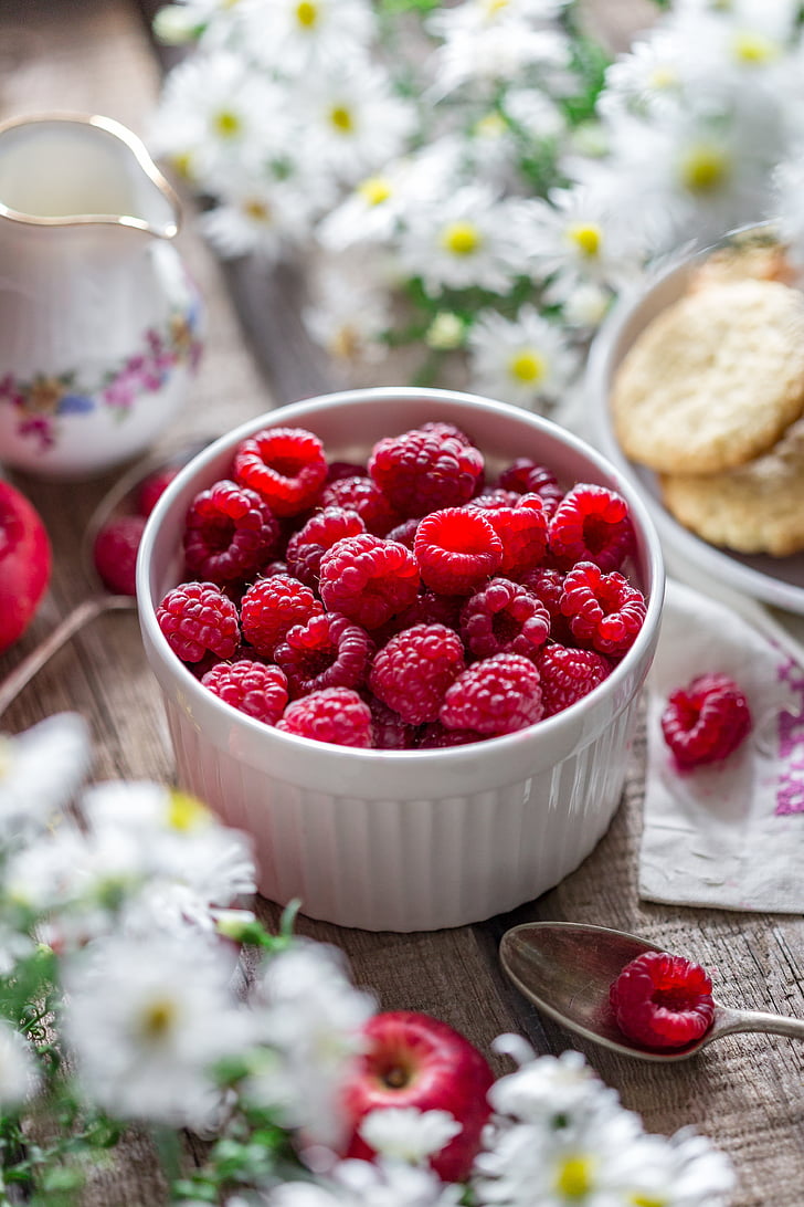 selective focus photography of raspberries in white ceramic bowl