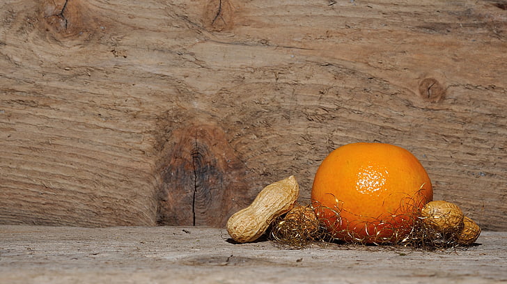 orange and peanuts on brown wooden board