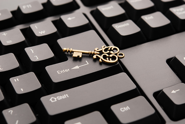 gold-colored skeleton key on computer keyboard