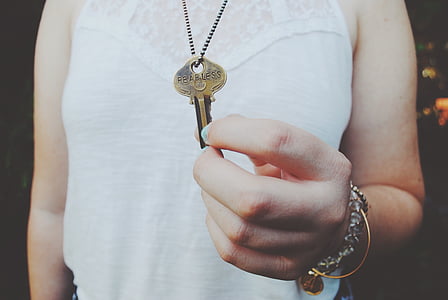 person holding gold-colored key