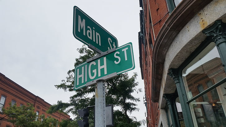 Main st. and High st. street sign under gray sky at daytime