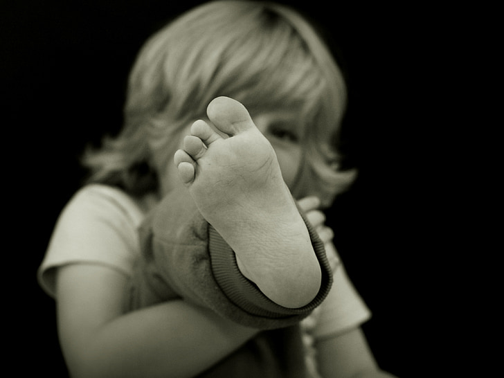 grayscale photography of children showing foot