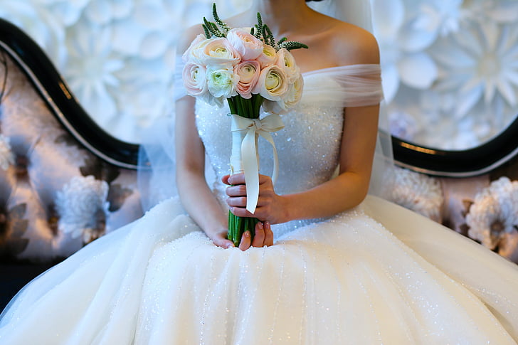 bride holding white and pink bouquet of flowers