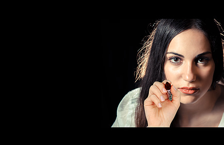 woman holding black lipstick