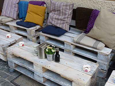 gray wooden pallet themed bench with pads beside table
