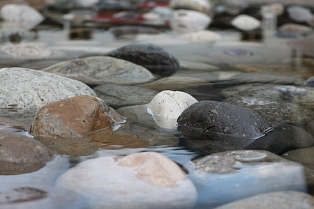selective focus photography of gray and black stone on river during daytime