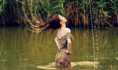 woman wearing brown and gray paisley dress on body of water