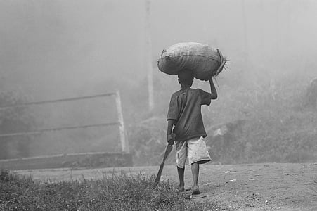 grayscale photography of man holding sack