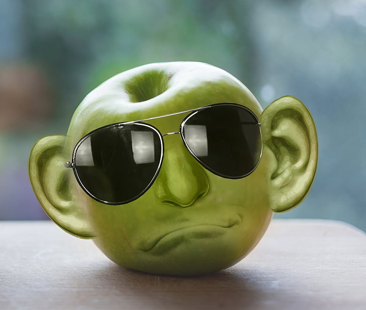 green apple formed into face with sunglasses