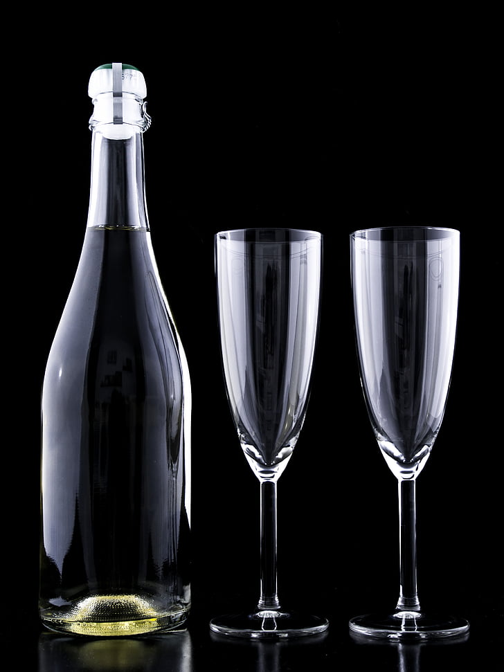 two clear flute champagne glasses and bottle