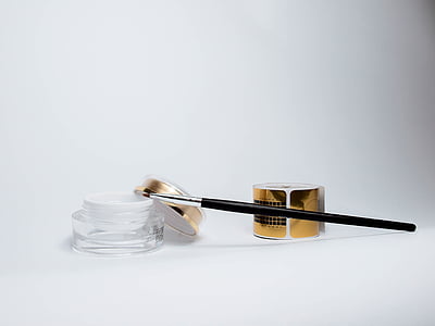 black makeup brush on clear cream jar