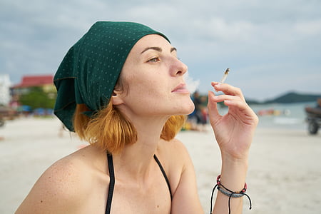 woman holding cigarette stick