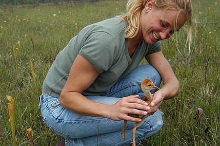 woman holding brown duckling
