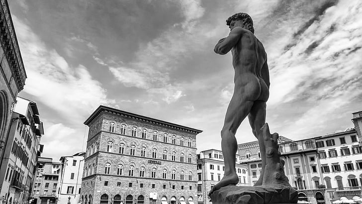 grayscale photo of Statue of David near buildings