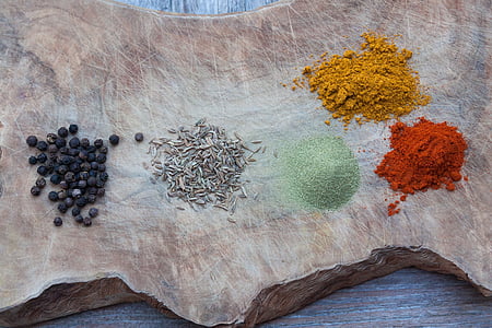five assorted spices on wood slab