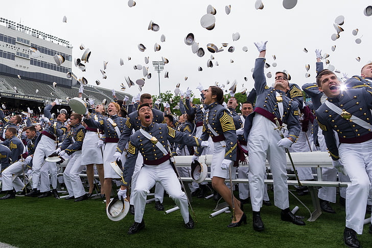 new graduates throwing their hats on the air during daytime