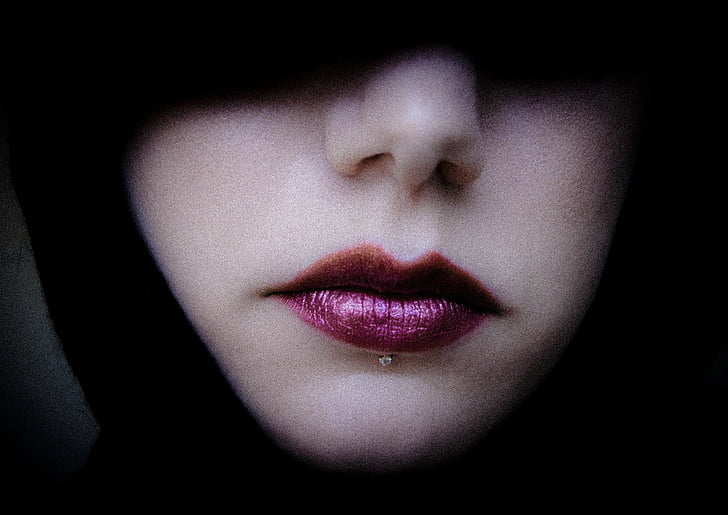 person wearing purple lipstick with silver lip piercing