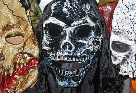 three brown, black, and white skullhead vinyl masks