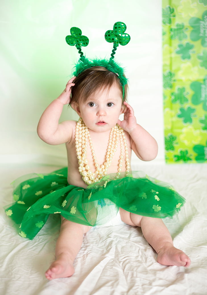 toddler wearing green tutu skirt and yellow necklace