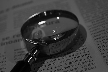 grey magnifying glass on white book