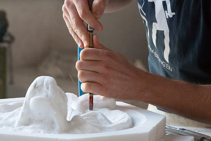 person molding a sculpture