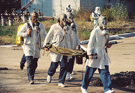 four men wearing brown gas masks