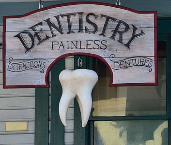 gray and red Dentistry Painless signage with tooth decor