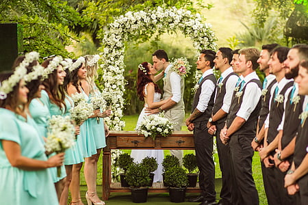 woman and man kissing in front of bridesmaid and groomsmen wedding ceremony