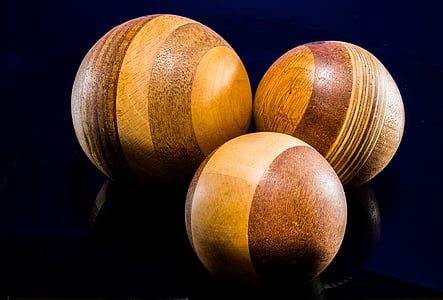 three brown croquet balls with black background