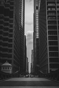grayscale photograpy of a road between man-made structures