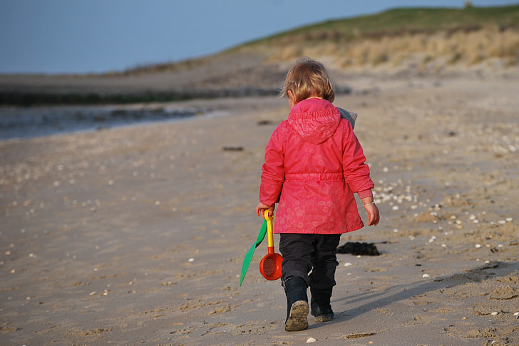 photo of girl walking on seashore