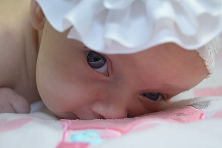 close-up photo of baby in white headband