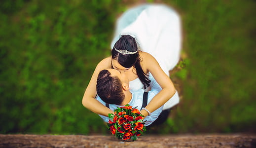 woman holding red rose bouquet while kissing man