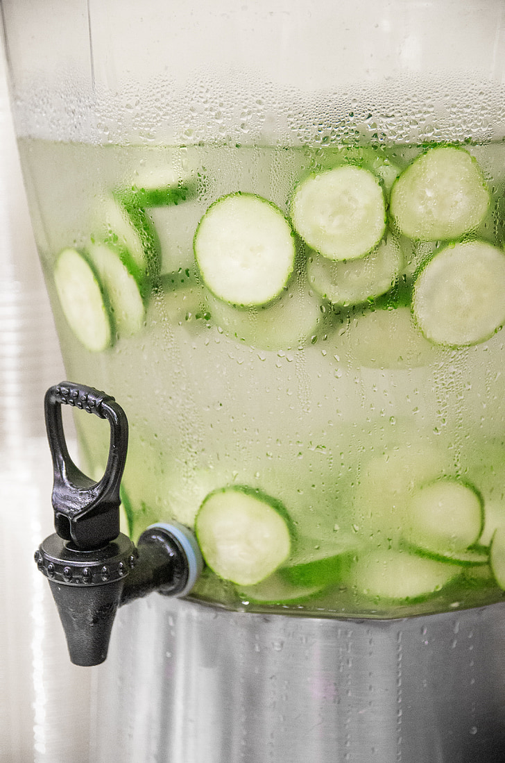 photo of water with sliced of cucumber in beverage dispenser